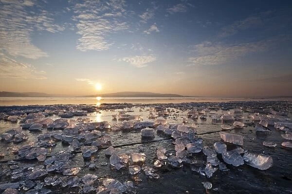 Chunks of ice lying on icy surface on the shore of Reichenau Island at sunset, Baden-Wuerttemberg, Germany, Europe - IMPORTANT Non-exclusive usage, retail calendar, duration Jan. 1, 2016 - Dec. 31, 2016, territory DEU, AUT, CHE -