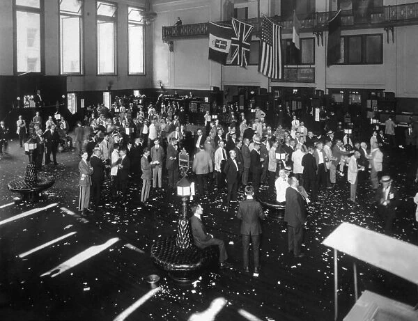 circa 1918: Businessmen crowd the floor of the New York Stock Exchange
