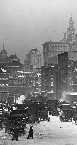 circa 1925: A view of a group of automobiles and wagons parked in the snow at the