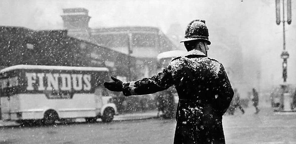 City Snow. 20th November 1965: A policeman directs traffic on a snowy day