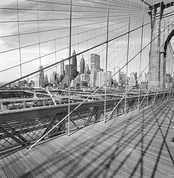 Cityscape through bridge cables, negative image