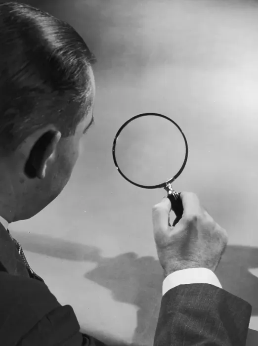 Framed Print : Close Up. circa 1935: A view over a man's shoulder as he looks through a magnifying glass Framed Print : Close Up. circa 1935: A view over a man's shoulder as he looks through a magnifying glass