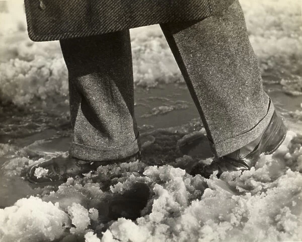 Close-up of mans feet and legs in slush