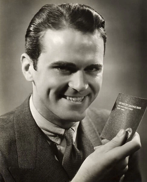 Close-up of smiling man with bank passbook