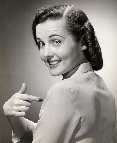 Close-up of smiling woman pointing at herself