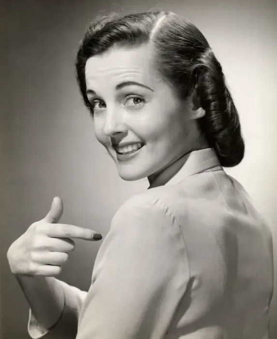 Framed Print : Close-up of smiling woman pointing at herself Framed Print : Close-up of smiling woman pointing at herself