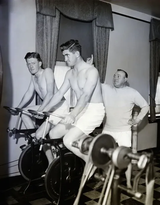 Framed Print : Coach And Men Riding Stationary Bikes