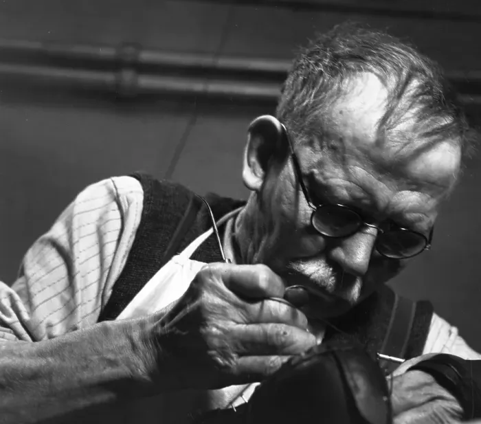 Framed Print : Cobbler. 1953: A cobbler stitching a shoe