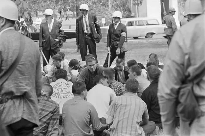 Framed Print : College Students Sitting in a Huddle While Being Watched by Federal Police Framed Print : College Students Sitting in a Huddle While Being Watched by Federal Police