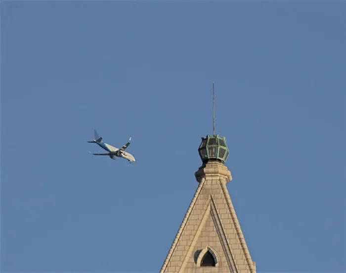 Framed Print : Flyby. A color photograph of a commercial jet flying past an older skyscraper Framed Print : Flyby. A color photograph of a commercial jet flying past an older skyscraper