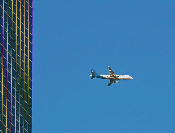 Flyby. A color photograph of a commercial passenger jet flying past a commercial