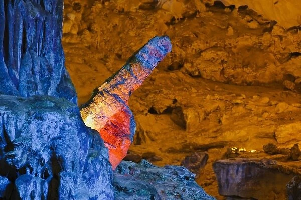 Colourfully, illuminated stone penis-shaped rock formation in Hang Sung Sot cave, Surprise Cave, Cave of Awe, a UNESCO World Heritage Site, stalactite cave in Halong Bay, Vietnam, Southeast Asia, Asia