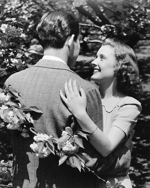 Couple embracing at blooming bush (B&W)