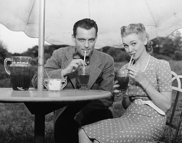 Couple having ice tea outdoors, (B&W), portrait