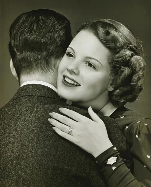 Couple hugging in studio, (B&W), close-up, portrait