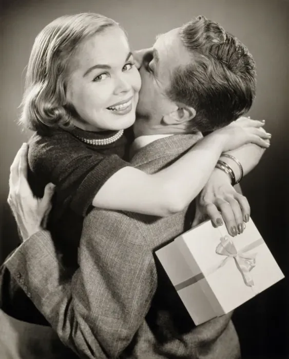 Framed Print : Couple hugging, woman holding gift, (B&W) Framed Print : Couple hugging, woman holding gift, (B&W)