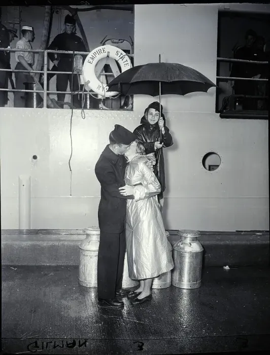 Framed Print : Couple Kiss Goodbye As Boy Holds Umbrell
