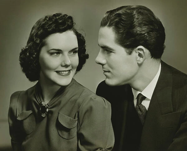 Couple looking in eyes, posing in studio, (B&W), portrait