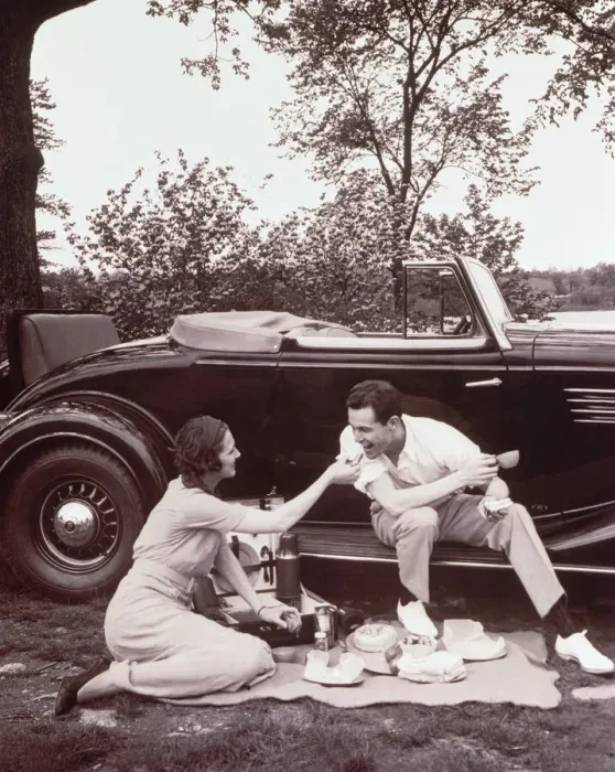 Framed Print : Couple picnicking, man sitting on car runningboard (B&W sepia tone) Framed Print : Couple picnicking, man sitting on car runningboard (B&W sepia tone)