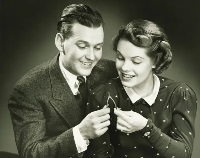 Framed Print : Couple pulling wishbone in studio, (B&W), close-up, portrait Framed Print : Couple pulling wishbone in studio, (B&W), close-up, portrait