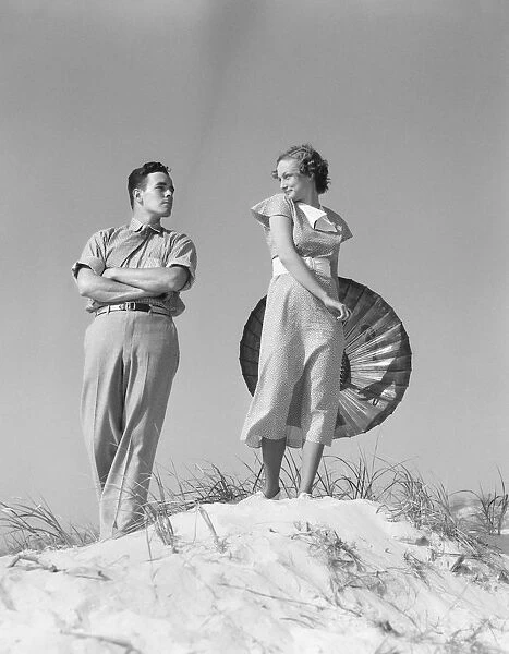 Couple at sand dune, man teasing