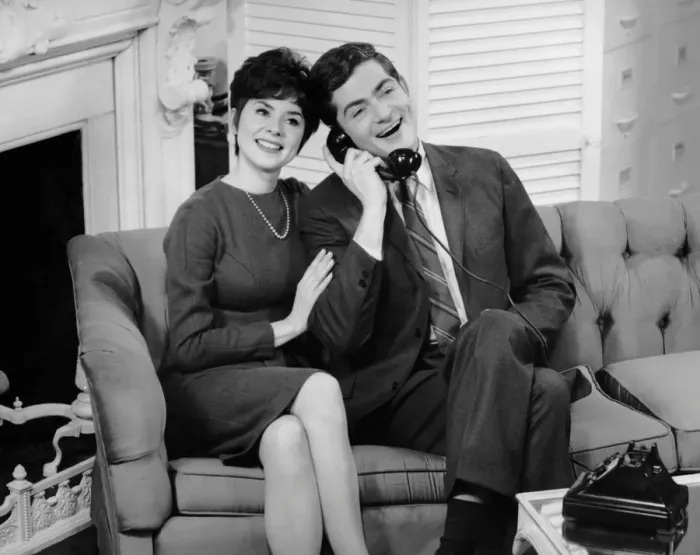 Framed Print : Couple sitting on couch w / telephone Framed Print : Couple sitting on couch w / telephone