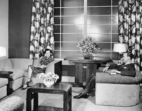 Couple sitting in living room reading