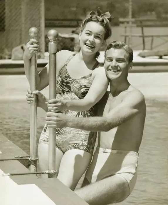 Framed Print : Couple standing at railings in pool, (B&W), portrait