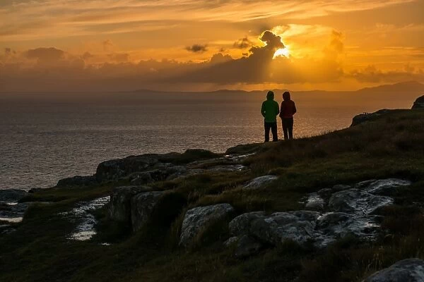 A couple wait for sunset at Nest Point viewpoint