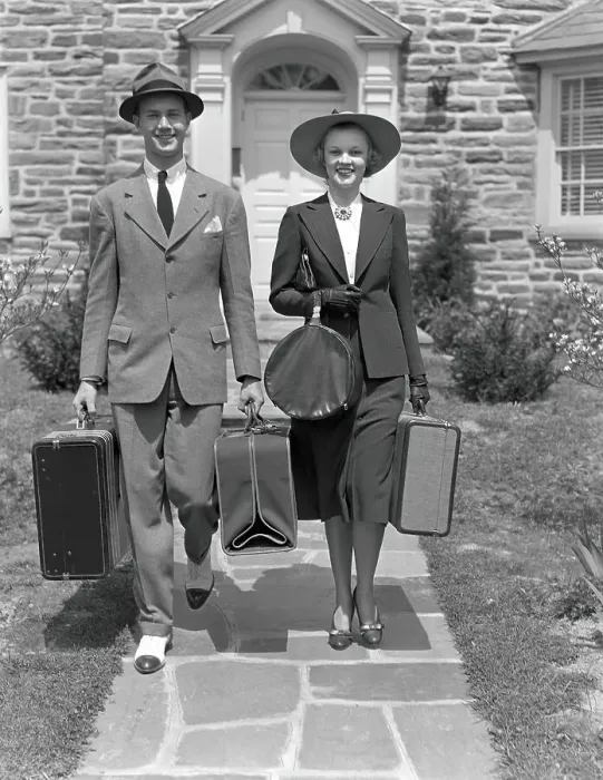 Framed Print : Couple walking along sidewalk, carrying suitcases Framed Print : Couple walking along sidewalk, carrying suitcases
