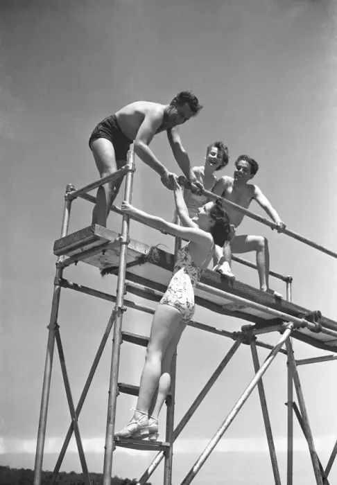 Framed Print : Two couples on springboard, (B&W), low angle view Framed Print : Two couples on springboard, (B&W), low angle view