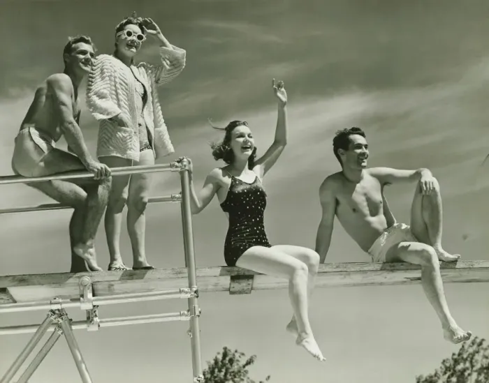 Framed Print : Two couples on springboard, (B&W), low angle view Framed Print : Two couples on springboard, (B&W), low angle view