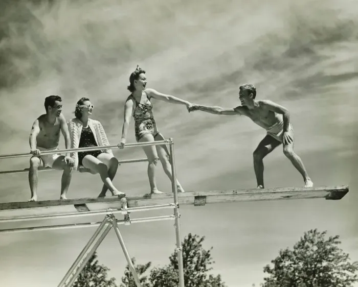 Framed Print : Two couples on springboard, (B&W), low angle view Framed Print : Two couples on springboard, (B&W), low angle view