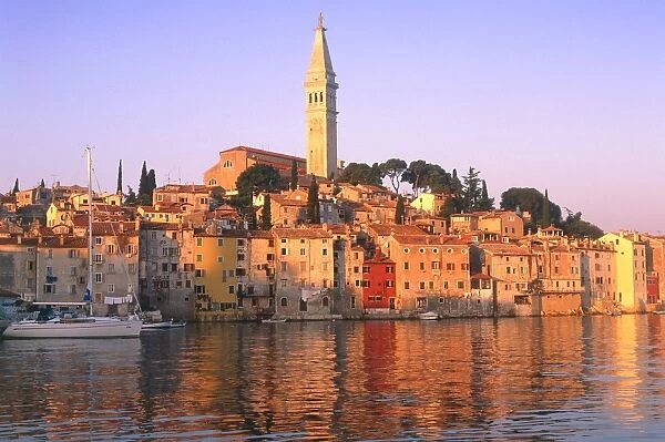 Croatia, Rovinj, church tower & harbour at sunrise seen from water
