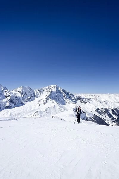 Cross-country skier ascending Hintere Schoentaufspitze Mountain, Solda, overlooking Ortler and Zebru Mountains, Alto Adige, Italy, Europe