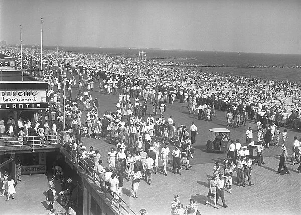 Crowd of people walking along beach, (B&W), elevated view