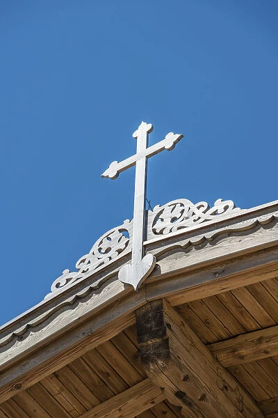 Crucifix on a wooden roof against a blue sky