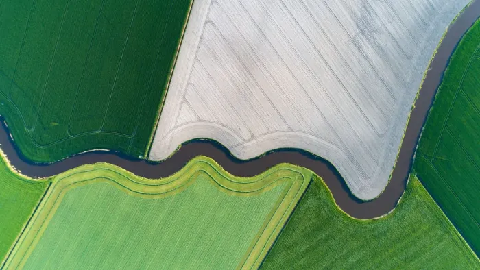 Framed Print : Cultivated land with natural stream seen from above Framed Print : Cultivated land with natural stream seen from above