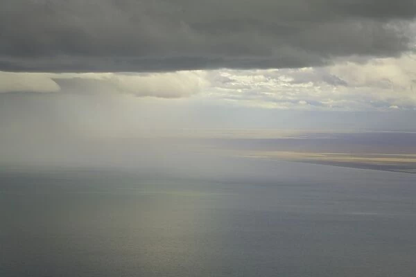 Cumulus clouds and rain showers over sea, aerial view