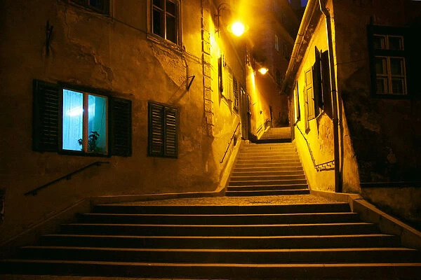 Curved narrow street at night, Sibiu, Romania