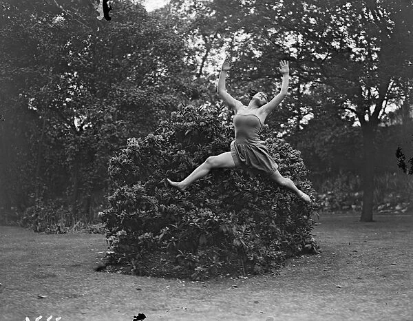 Dancing Dryad, a tunic clad Margaret Morris dancer leaping barefoot over the grass