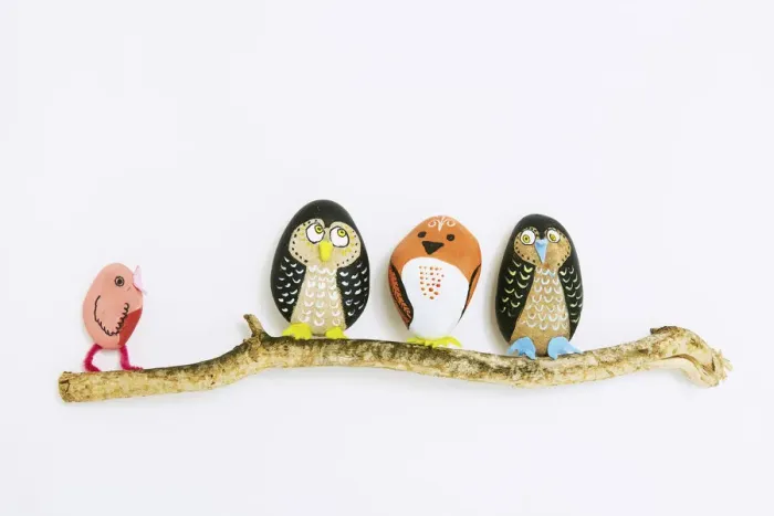Framed Print : Decorated painted stone birds perching on a branch Framed Print : Decorated painted stone birds perching on a branch