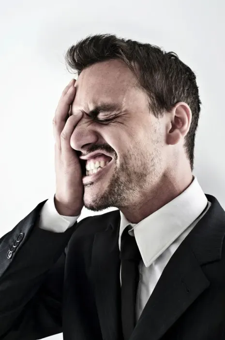 Framed Print : Desperate young man wearing a suit covering his face with his hand, screaming Framed Print : Desperate young man wearing a suit covering his face with his hand, screaming