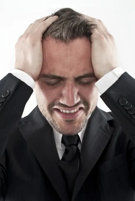 Framed Print : Desperate young man wearing a suit holding his hands to his face, worried Framed Print : Desperate young man wearing a suit holding his hands to his face, worried