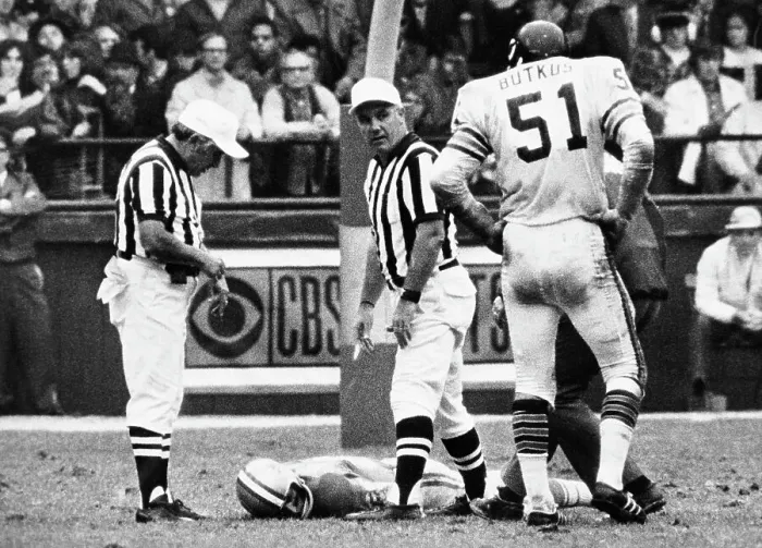 Framed Print : Dick Butkus Watches as Chuck Hughes Lies on Field Framed Print : Dick Butkus Watches as Chuck Hughes Lies on Field