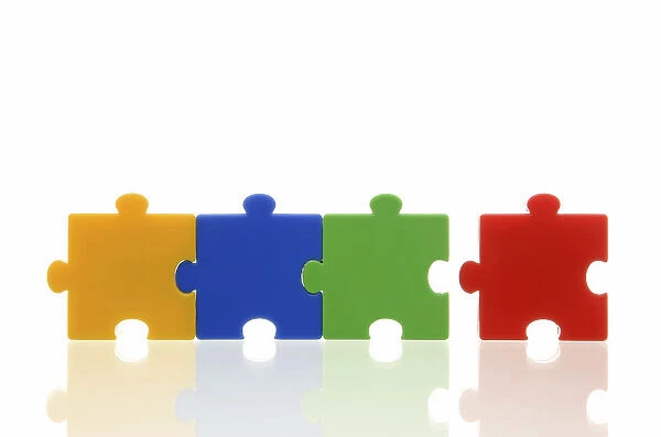 Different coloured puzzle pieces, three puzzle pieces connected, one single puzzle piece, symbolic image for team, series
