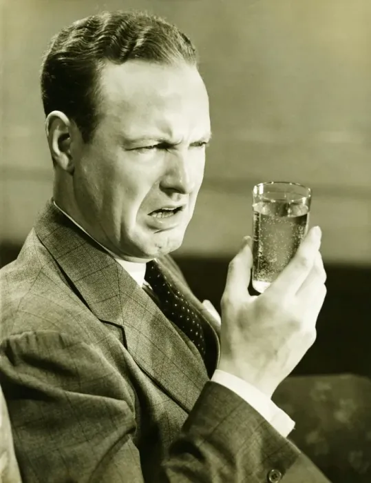Framed Print : Disgusted man looking at glass of water, (B&W) Framed Print : Disgusted man looking at glass of water, (B&W)