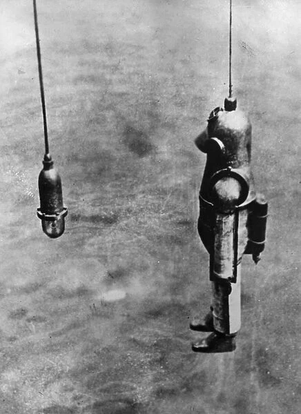 Diver. circa 1900: A diver goes down from the salvage ship Blakey to the