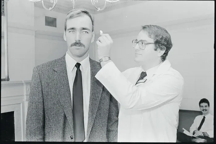 Framed Print : Doctor Holding Polymer Wafer to Head of Patient