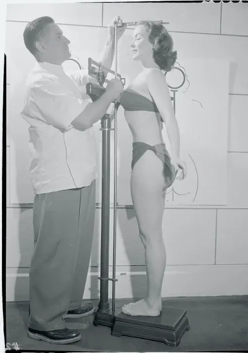 Framed Print : Doctor Measuring Woman's Height Framed Print : Doctor Measuring Woman's Height